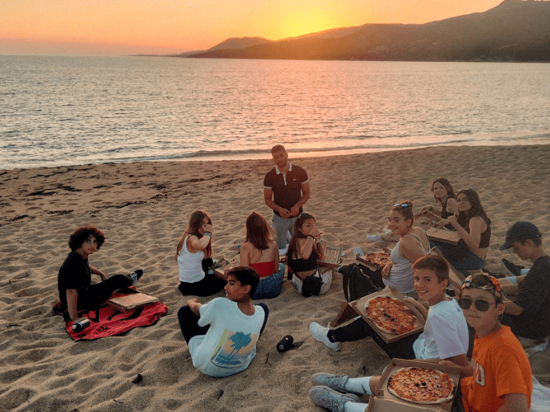 Repas pizza sur la plage en Corse en colo La Belle Corse de cet été ouverte aux 14-17 ans