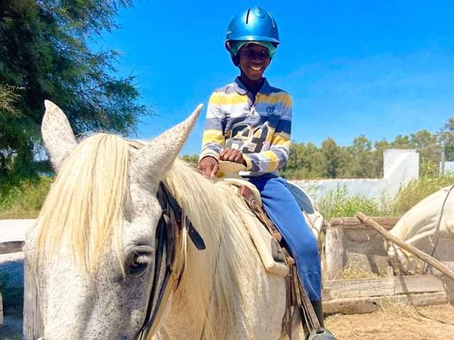 Jeune garcon qui fait du cheval en colo Equitation en Ardèche cet été