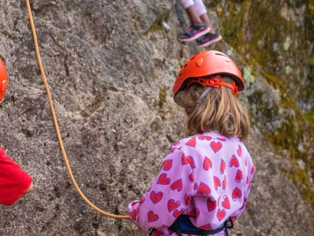 Jeune fille qui fait de l'escalade en colo de vacances multi activités cet été