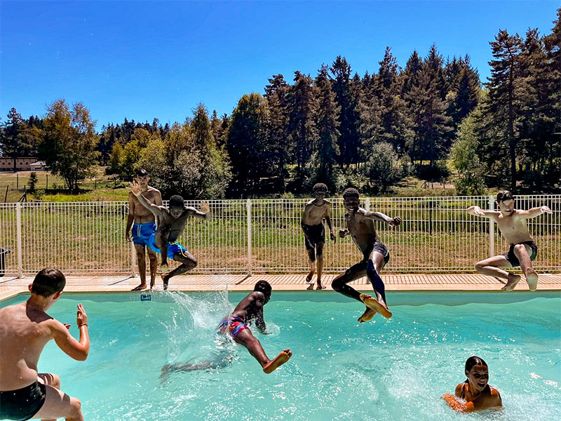 Enfants sautant dans la piscine à mont joyeux colonie de vacances