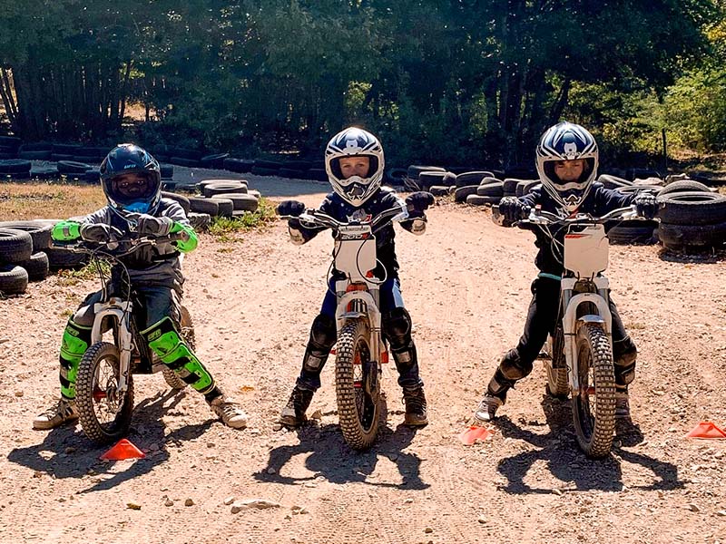 Trois enfants à moto en colonie de vacances sports mecaniques