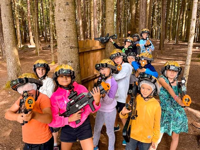 groupe d'enfants faisant du laser game extérieur en été