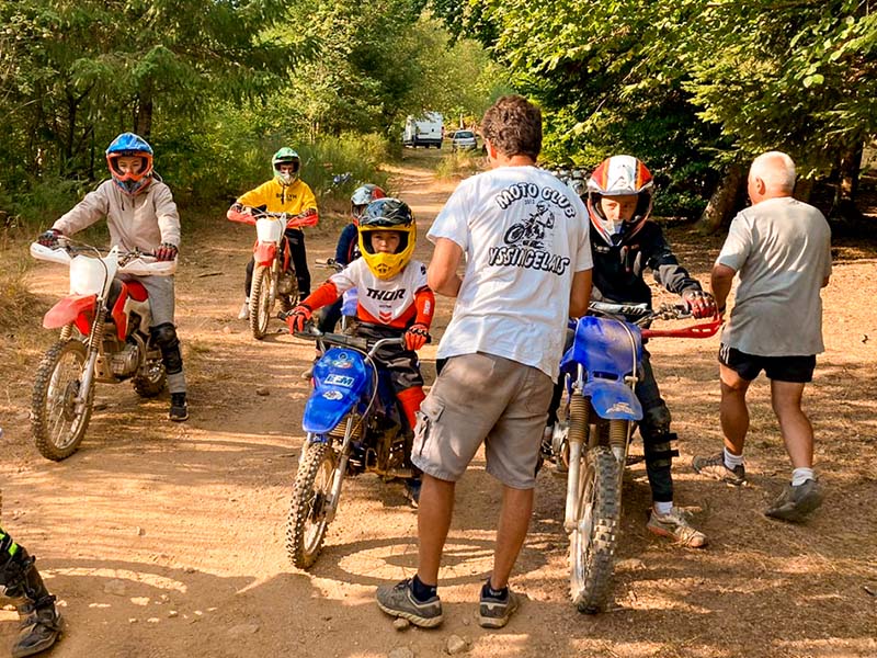 Moniteur de moto avec enfants de 10 ans en colonie de vacances