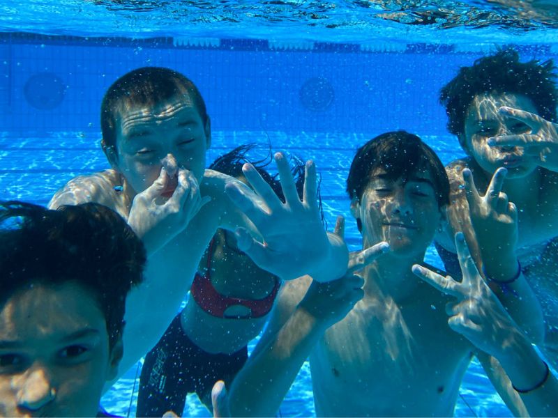 Enfants dans la piscine qui s'amusent en colo de vacances