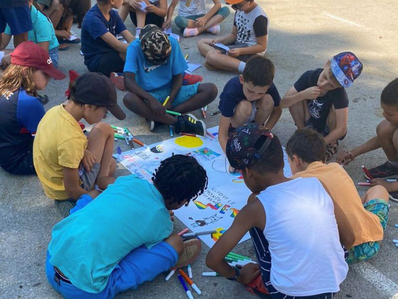 Groupe de jeunes garçons qui dessinent et s'amusent en colo de vacances en Ardèche cet été