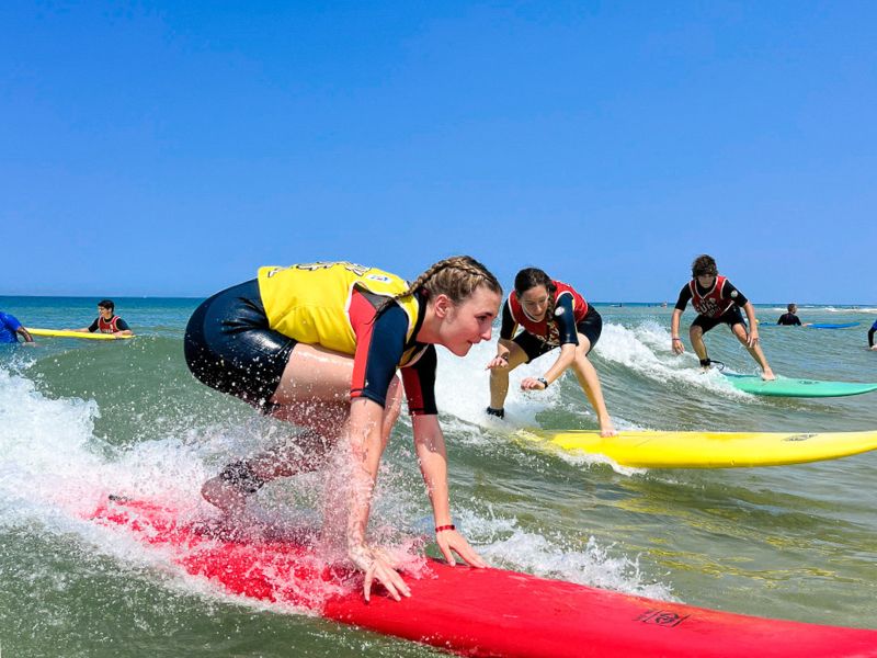 Jeunes qui font du surf et s'entrainent en colo de vacances cet été