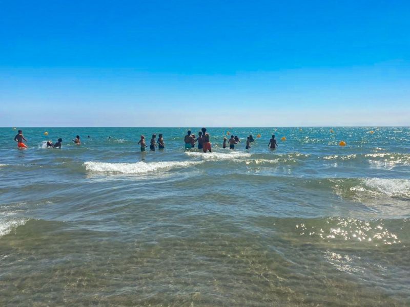 Groupe de jeunes en colo de vacances qui profite de la mer pour se baigner cet été