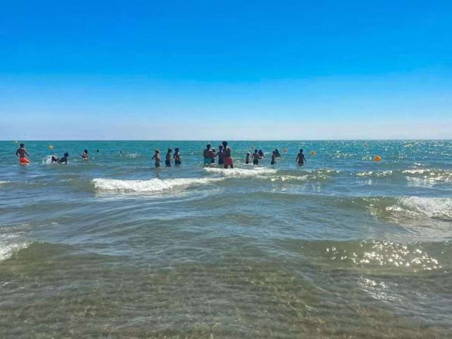 Groupe de jeunes en colo de vacances qui profite de la mer pour se baigner cet été