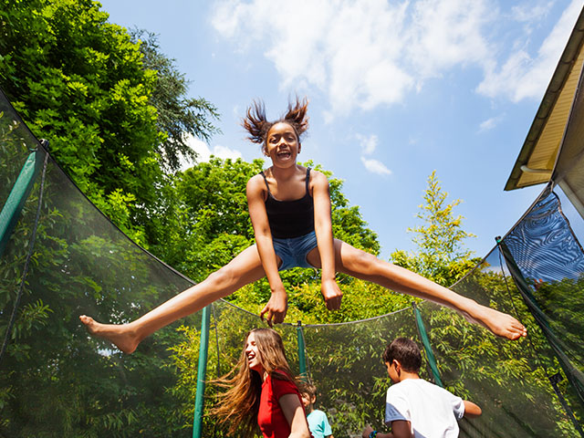 jeune fille sautant sur un trampoline en colo de vacances
