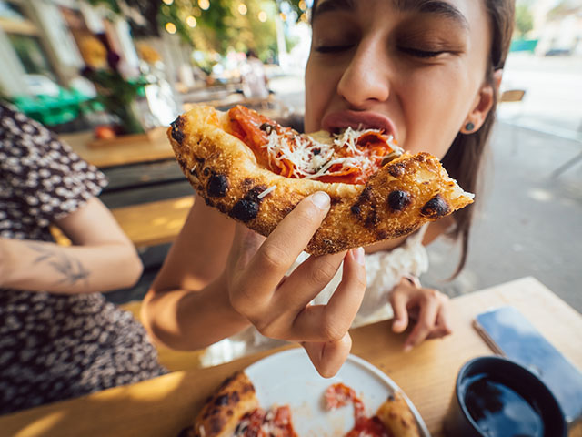 jeune fille mangeant une pizza specialite culinaire italienne lors d'un sejour itinerant a l'etranger