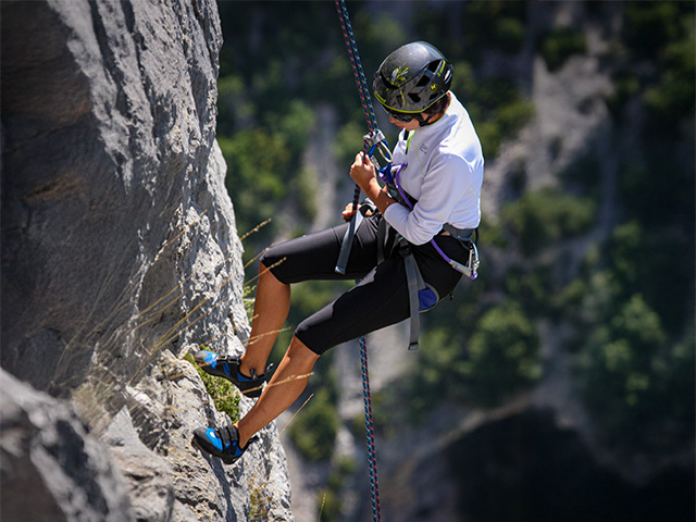 femme descente en rappel montagne abrupte chaîne montagneuse