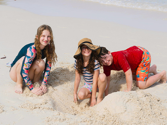 préadolescents 13 ans à la plage jouant dans le sable