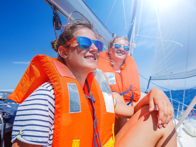 adolescentes avec leur gilet de sauvetage sur un bateau en mer colo été