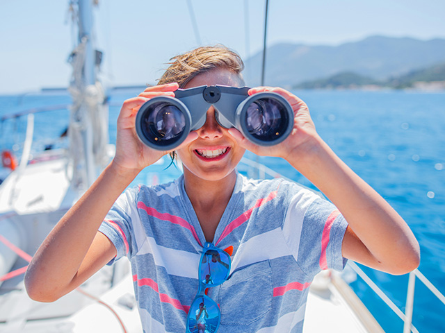 ados avec des jumelles sur un bateau en colo sur la côte d'azur