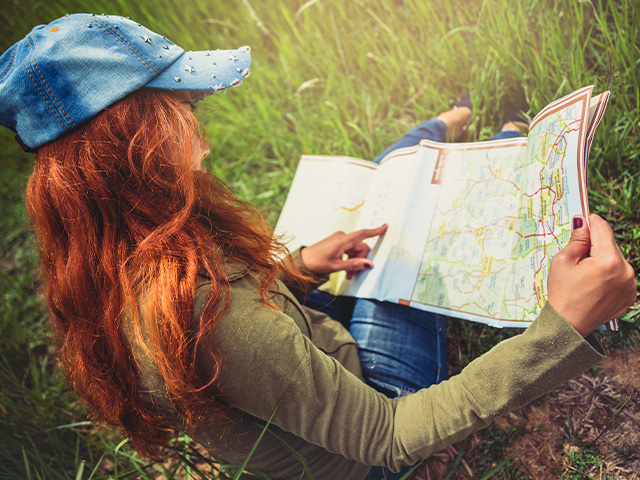 jeune fille et sa carte lors d'une course d'orientation dans la nature