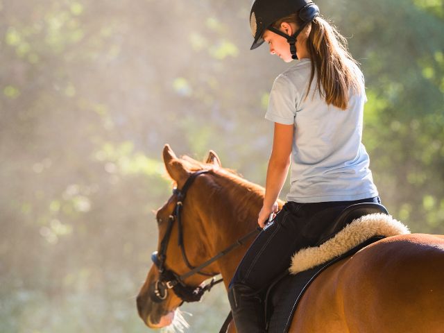 Ado qui fait de l'équitation en colonie de vacances cet été