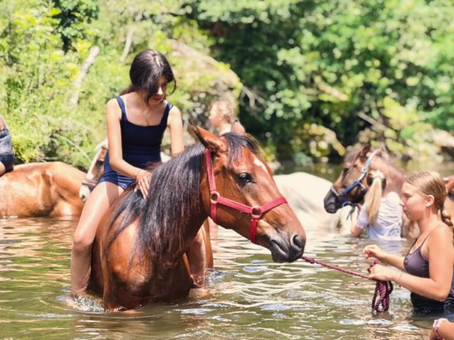 Pré ado qui fait de l'équitation dans la rivière en colo de vacances cet été