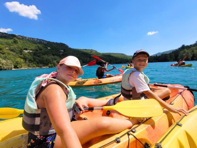 Deux jeunes de 7 ans en colonie de vacances qui font du kayak sur le lac de Ste Croix