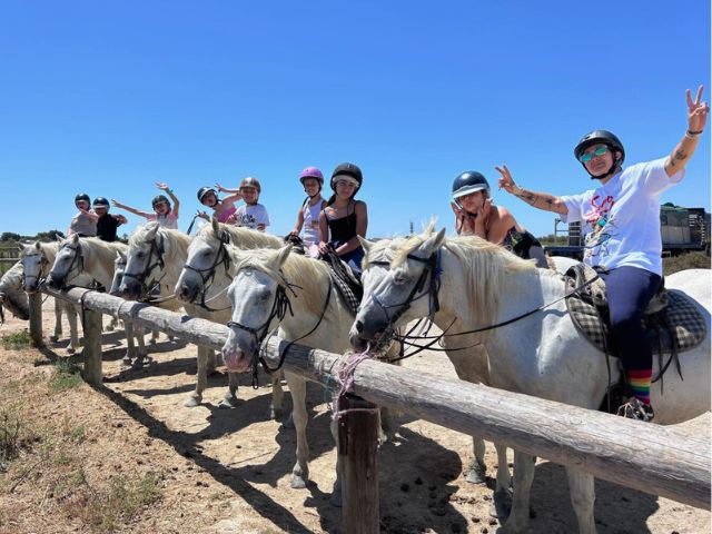 Groupe de pré ados heureux de faire de l'équitation en colo de vacances cet été