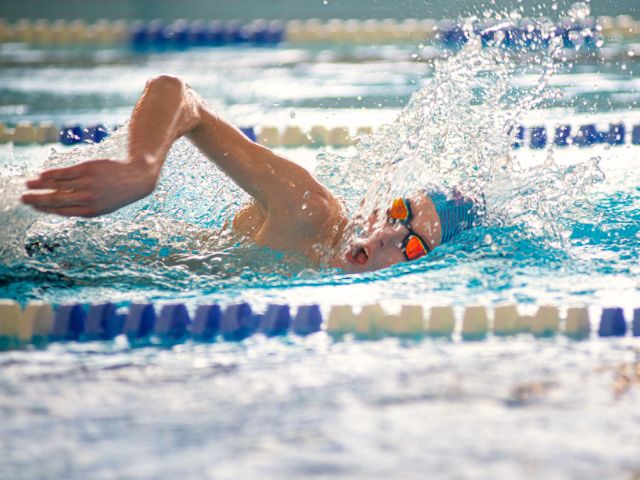 Jeune en train de nager à la piscine cet été