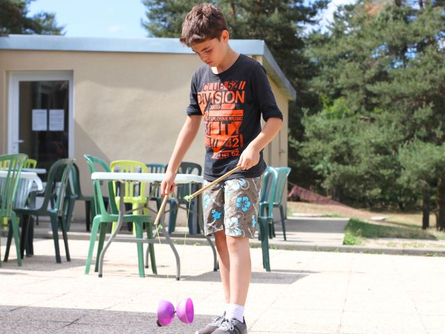 Jeune garçon en colo cirque qui fait du diabolo