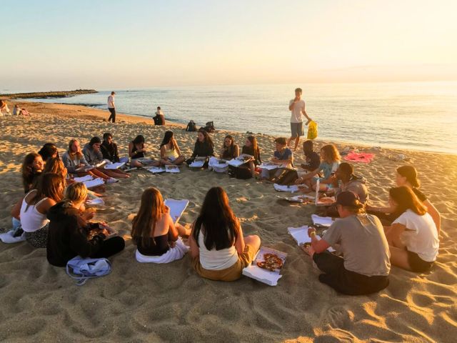 Groupe ados sur la plage qui se détendent et profitent de leur colonie de vacances au Portugal 