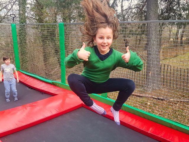 Jeune enfant de 10 ans qui fait du trampoline en colo de vacances multi activités cet été 