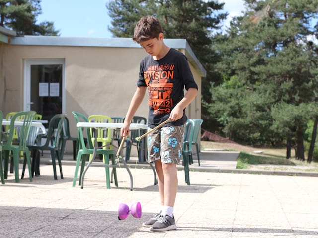 Jeune garçon qui fait du diabolo en colonie de vacances itinérante cet été