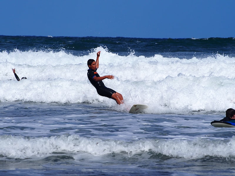 Vue sur un jeune qui pratique le surf à Anglet en colonie de vacances