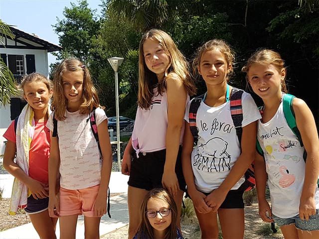 Groupe de jeunes filles qui sont en colo de vacances et qui rentrent de la plage 