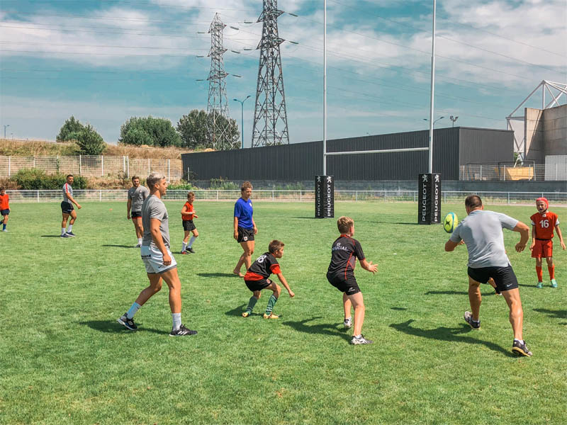 Groupe d'enfants qui jouent au rugby en colonie de vacances cet été