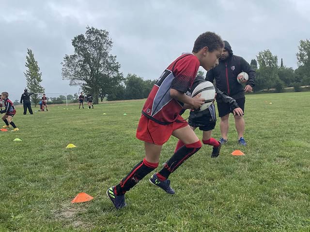 Enfant jouant au rugby en colonie de vacances de printemps