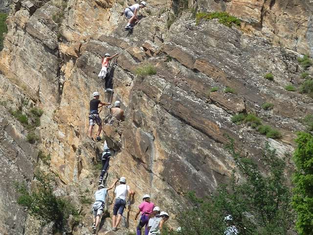 Jeunes qui pratiquent l'escalade lors de leur colo de vacances dans les Pyrénées durant l'été