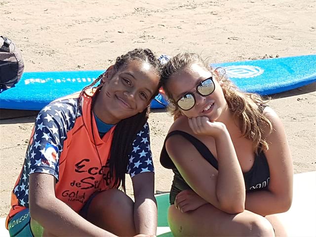 Deux jeunes filles avec le sourire qui profitent de leur colo de vacances à la montagne et à l'océan