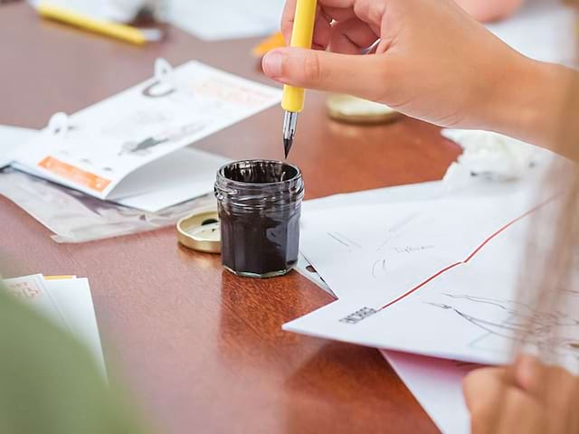 enfant apprenant à utiliser l'encre de chine en colonie de vacances manga