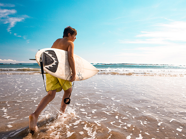 adolescent avec planche de surf été colonie de vacances