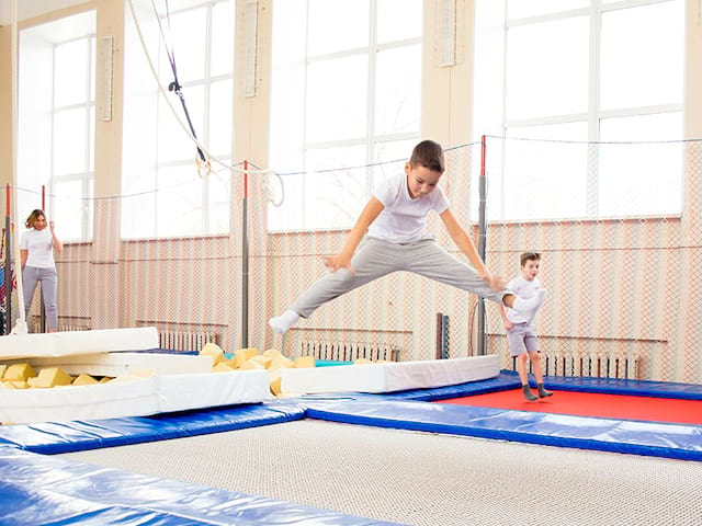 garçon faisant du trampoline en colonie de vacances