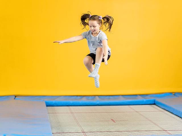 fillette faisant du trampoline en colonie