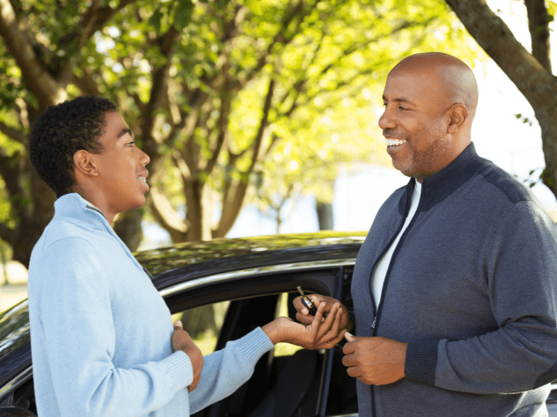 Jeune garçon et son moniteur d'auto école lors d'une leçon de conduite en colo de vacances cet été