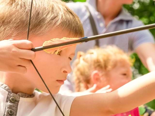 Jeune garçon en colo de vacances tir à l'arc cet été dans le Vercors