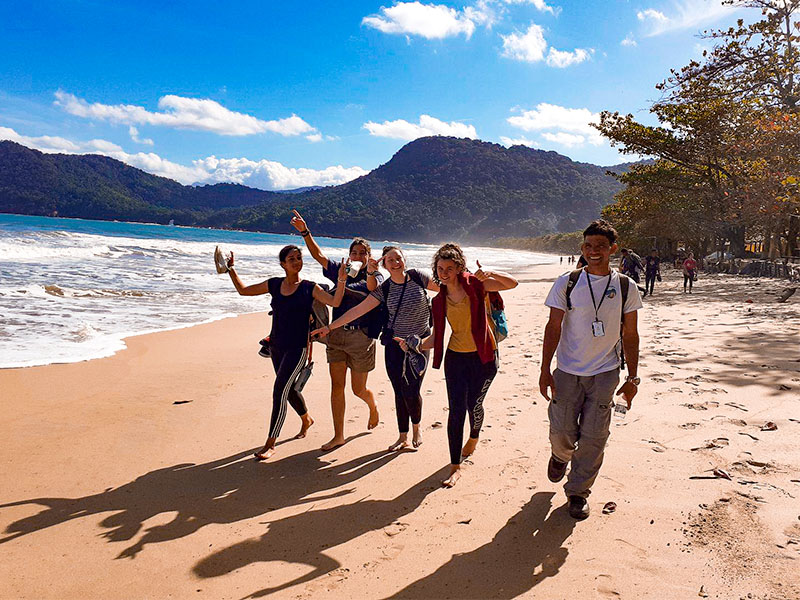 Groupe d'ados en colonie de vacances au Brésil cet été qui se promène sur la plage