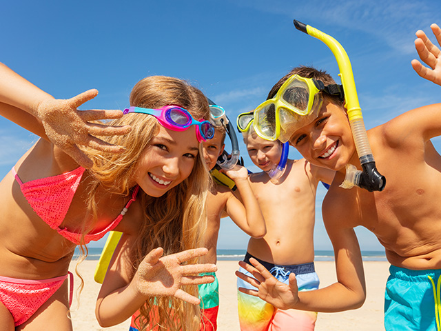 quatre jeunes d'une dizaine d'années jouant sur la plage en colo été