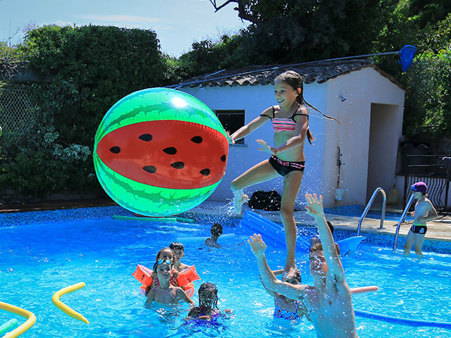 jeux avec un ballon géant dans la piscine du centre de vacances en colo