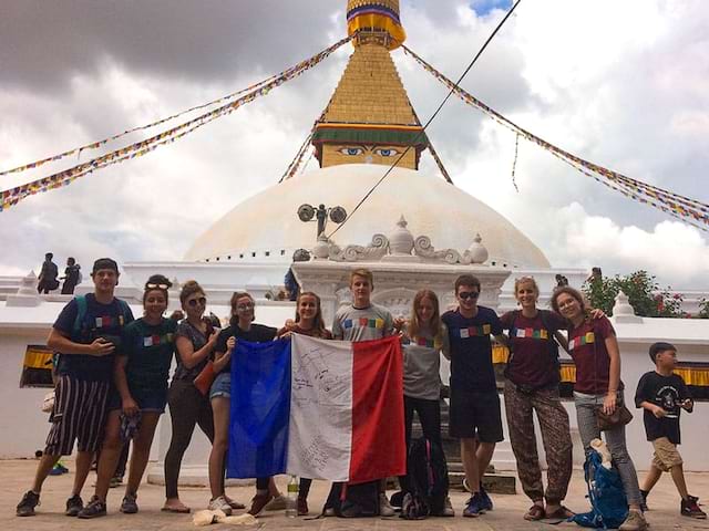 jeunes avec drapeau francais devant un temple au népal