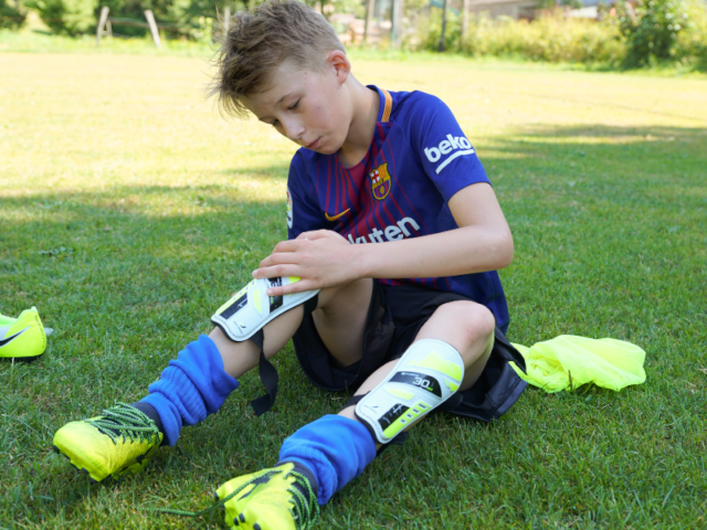 Jeune garçon qui fait du foot en colo de vacances cet été