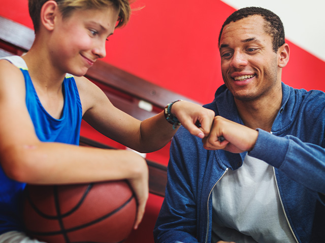 un coach et un jeune adolescent avant un match de basket