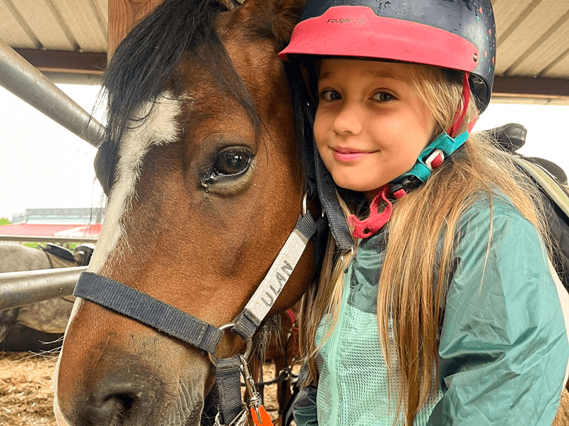 Jeune fille en colonie de vacances estivale Poney pour les 4-10 ans