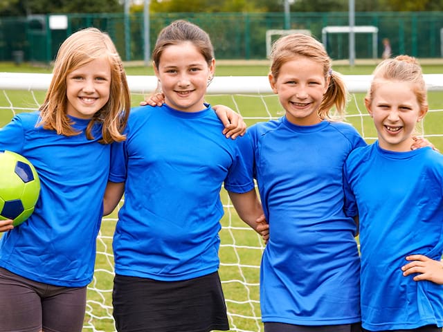 jeunes filles en tenue de football avec ballon dans la main 