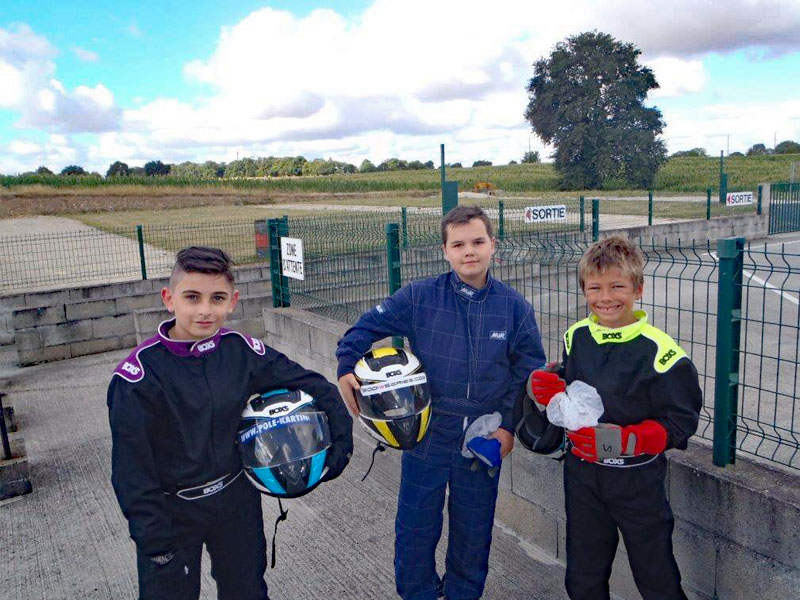 Trois enfants en tenue de karting en colo
