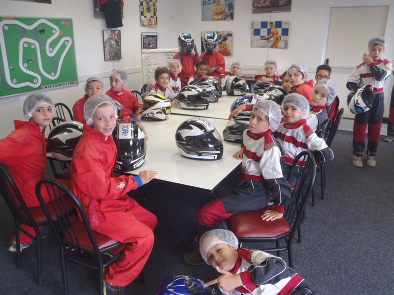 Groupe d'enfants en colonie de vacances apprenant à conduire un kart 